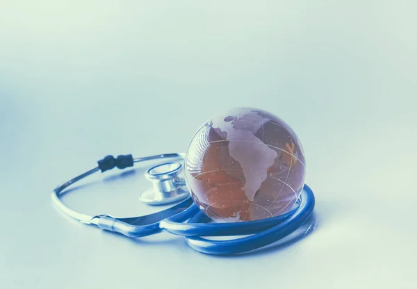 Globe and stethoscope, on the gray background — Stock Photo, Image