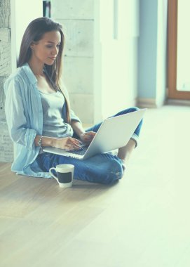 genç güzel kadın evde laptop ile katta oturuyor.