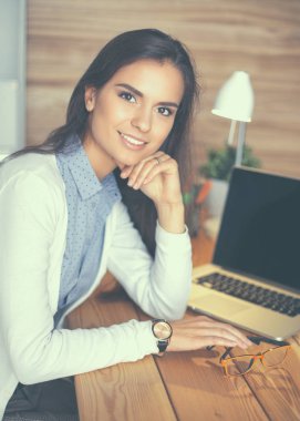 Masada oturan genç bir kadın.