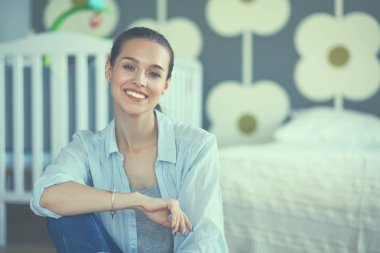 Çocuk karyolası yakın katta oturan genç kadın