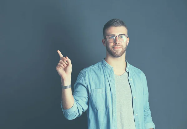 Portrait of a smiling young man pointing up — Stock Photo, Image