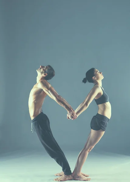 Młoda para razem praktykują acro jogi maty w studio — Zdjęcie stockowe