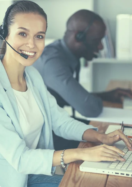 Mensen uit het bedrijfsleven met headsets computers gebruiken in office — Stockfoto