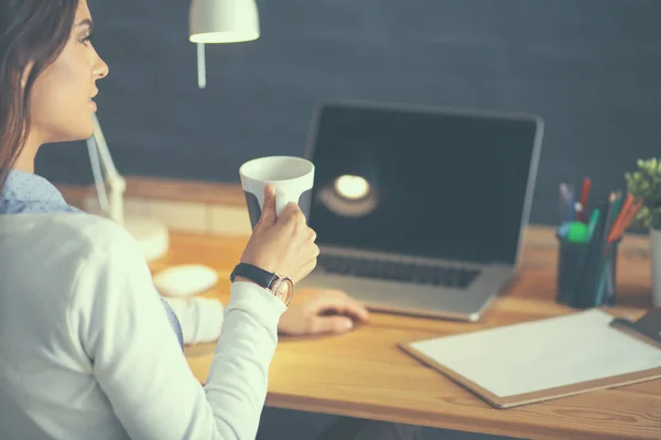 Portrait jeune femme détendue assise à son bureau tenant une tasse de café — Photo