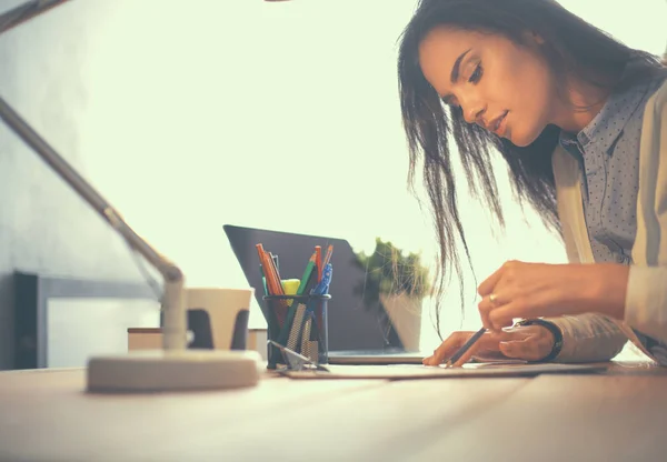 Giovane donna che lavora seduta ad una scrivania — Foto Stock