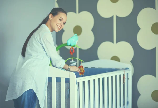 Jonge vrouw stond in de buurt van childrens kinderbed — Stockfoto