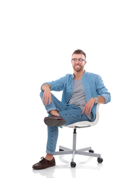 Ung man som sitter på stolen isolerade över vit bakgrund — Stockfoto