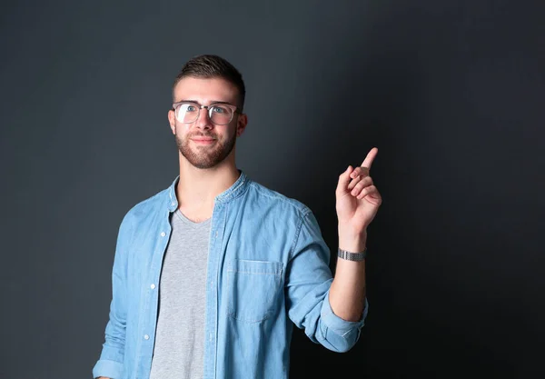 Portret van een glimlachende jonge man die omhoog wijst — Stockfoto