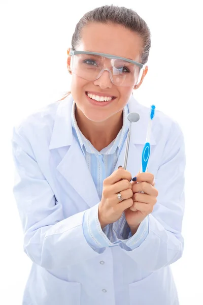 Piękna kobieta dentysta lekarz gospodarstwa i pokazując szczoteczkę do zębów izolowane na białym tle — Zdjęcie stockowe