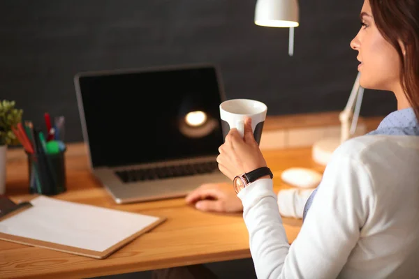 Portrait jeune femme détendue assise à son bureau tenant une tasse de café — Photo