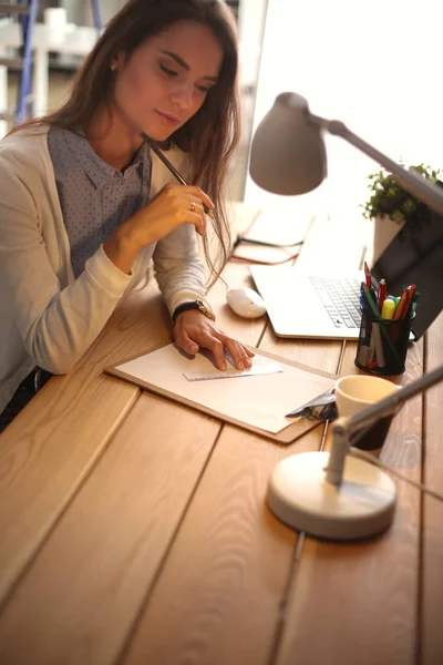 Mladá žena pracující za stolem — Stock fotografie