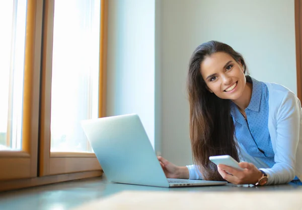 Młoda kobieta stojącego obok biurka z laptopa — Zdjęcie stockowe