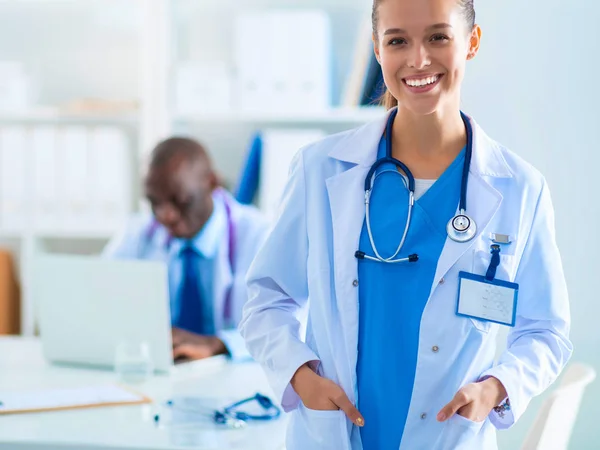 Una dottoressa sorridente con una cartella in uniforme all'interno — Foto Stock