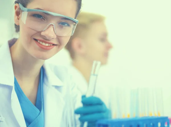 Woman researcher is surrounded by medical vials and flasks, isolated on white background — Stock Photo, Image