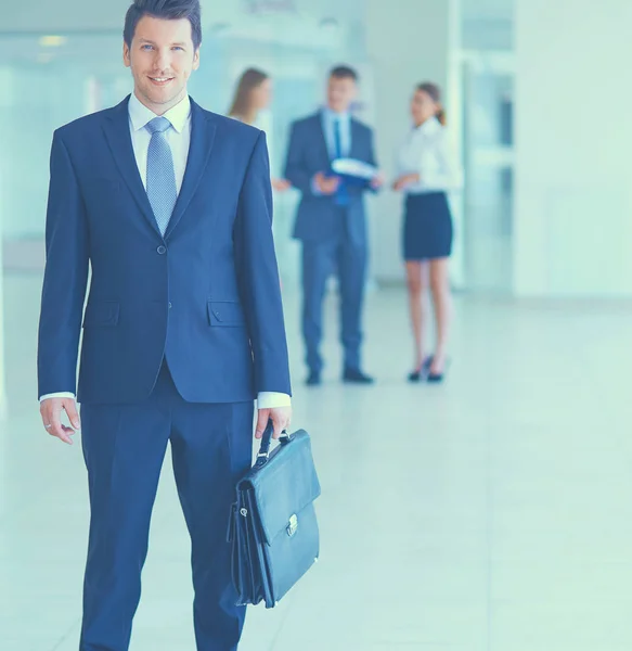 Porträtt av ung affärsman i office med kollegor i bakgrunden — Stockfoto