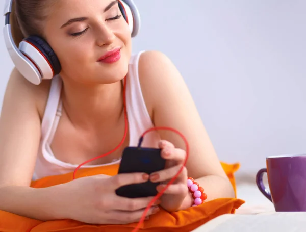 Młoda kobieta, leżąc na podłodze i słuchać muzyki — Zdjęcie stockowe