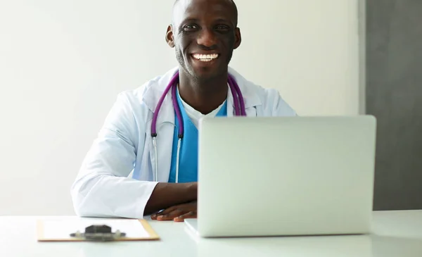 Junger afrikanischer Arzt arbeitet am Laptop am Schreibtisch — Stockfoto