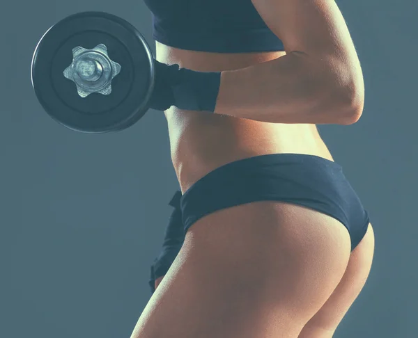 Атлетичная женщина накачивает мускулы гантелями — стоковое фото