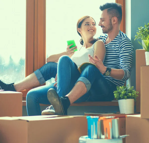 Par som flyttar i huset sitter på fönsterbrädan — Stockfoto
