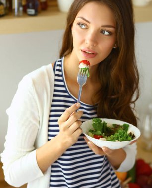 Salata yemek ve karışık salata tutan genç kadın