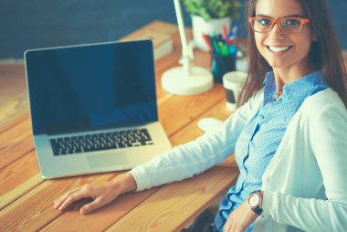 Masada oturan genç bir kadın.