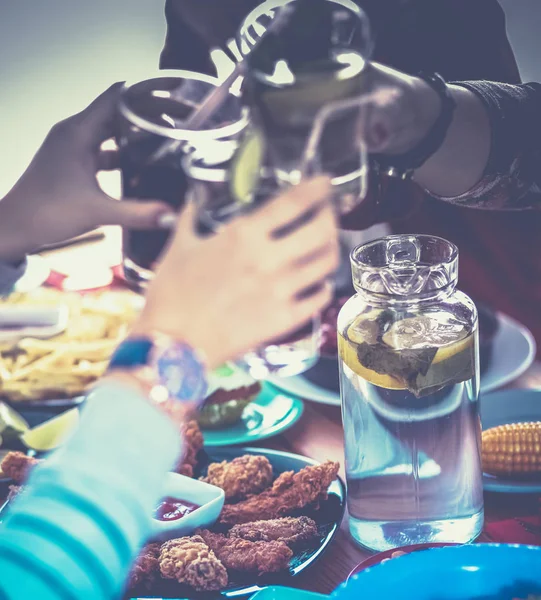 Yemek masasında içki içen insanlar.