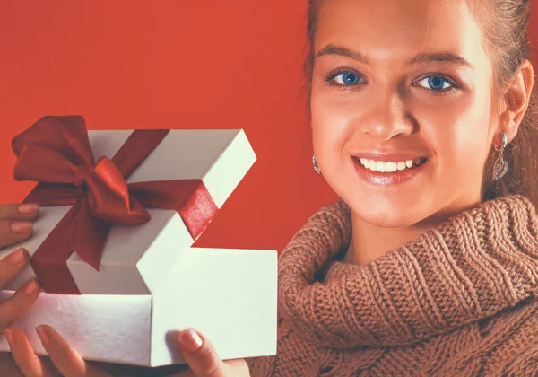 Young woman is standing while holding a bag of gifts over her shoulder — Stock Photo, Image