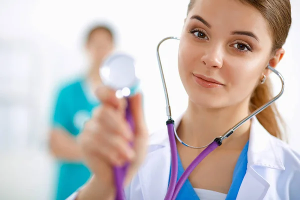 Mladá doktorka poslouchající stetoskop stojící v nemocnici — Stock fotografie