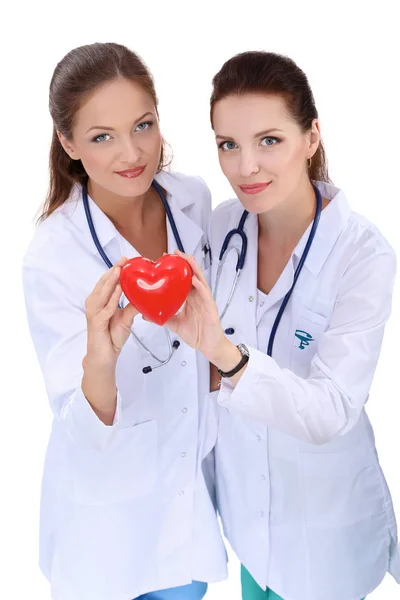 Дві жінки-лікар тримає червоне серце, ізольовані на білому тлі — стокове фото