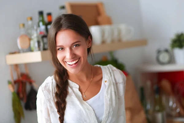 Ung kvinna står nära skrivbord i köket — Stockfoto