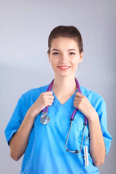 Smiling female doctor in uniform standing at hospital — Stock Photo, Image