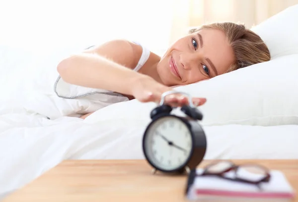 Jeune femme endormie et réveil dans la chambre à coucher à la maison — Photo