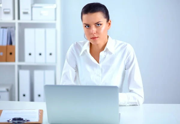 Jovem mulher sentada à mesa do escritório com laptop — Fotografia de Stock