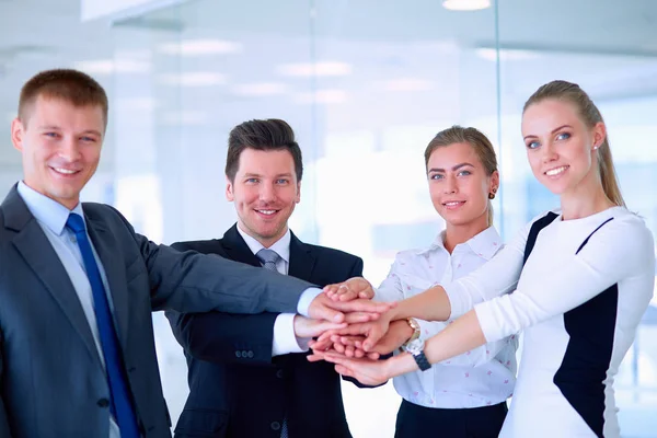 Business team joining hands together standing in office Royalty Free Stock Photos