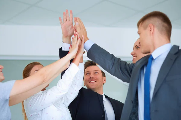 Business team joining hands together standing in office — Stock Photo, Image