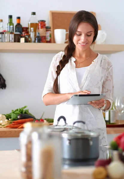 年轻女人在厨房里用平板电脑做饭 — 图库照片