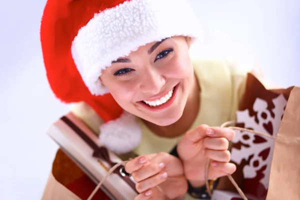 Mujer sonriente en sombrero de santa con muchas cajas de regalo sobre fondo blanco —  Fotos de Stock