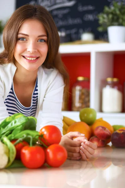 Junge Frau steht neben Schreibtisch in der Küche — Stockfoto