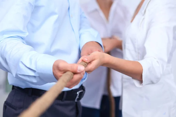 Konzeptbild eines Geschäftsteams, das ein Seil als Element der Teamarbeit im Vordergrund verwendet — Stockfoto