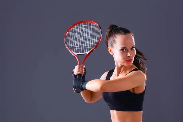 Mujer jugando tenis sobre fondo gris — Foto de Stock
