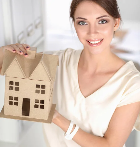 Portrait of female architect holding a little house, standing in office — Stock Photo, Image
