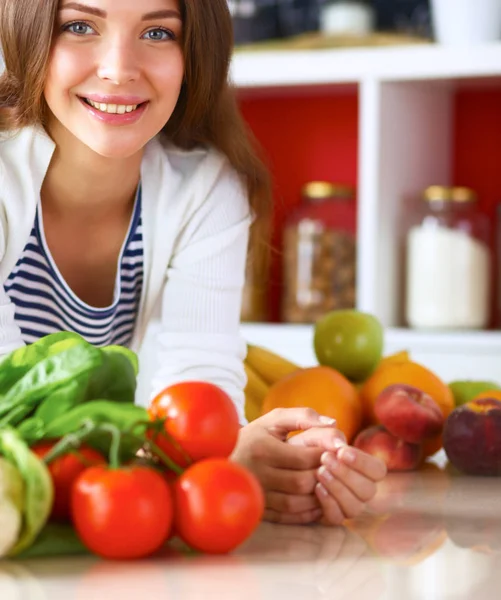 Junge Frau steht neben Schreibtisch in der Küche — Stockfoto