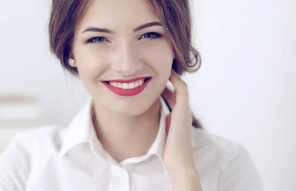 Attractive businesswoman standing near wall in office — Stock Photo, Image