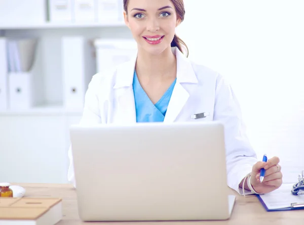 Női orvos ül az asztalon, és dolgozik egy laptop — Stock Fotó