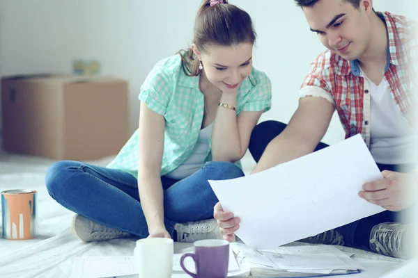 Young couple sitting on floor and calculating about they savings — Stock Photo, Image