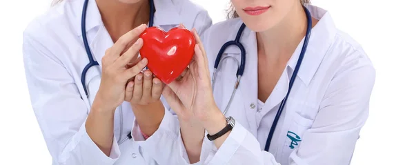 Kırmızı kalp taşıyan iki kadın doktor, beyaz arka planda izole edilmiş. — Stok fotoğraf