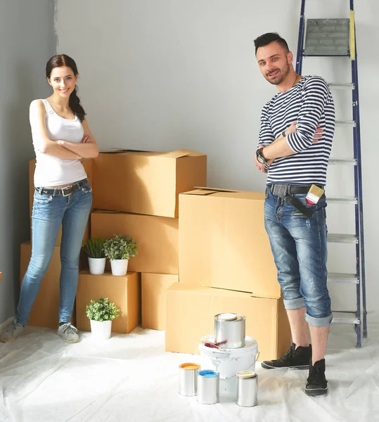 Happy young couple unpacking or packing boxes and moving into a new home — Stock Photo, Image