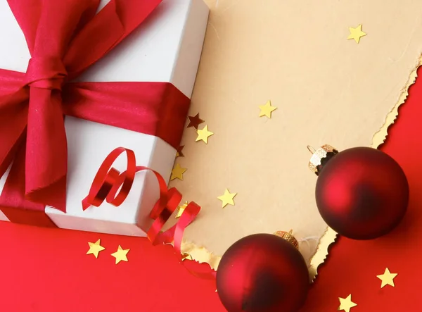 Caja de regalo de Navidad en tarjeta con bolas rojas y estrellas de oro —  Fotos de Stock