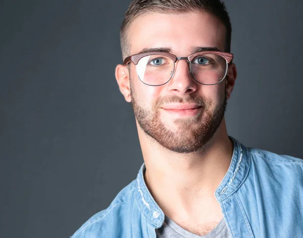 Retrato de homem casual feliz de pé isolado em um fundo escuro — Fotografia de Stock