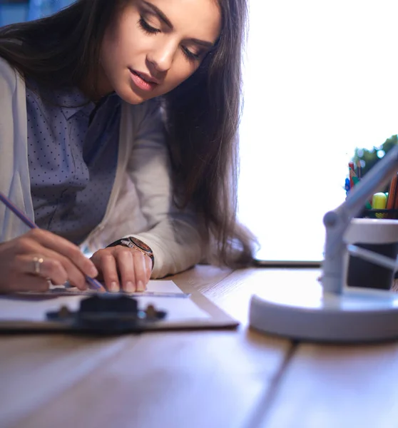 Jonge vrouw werkend zittend aan een bureau — Stockfoto